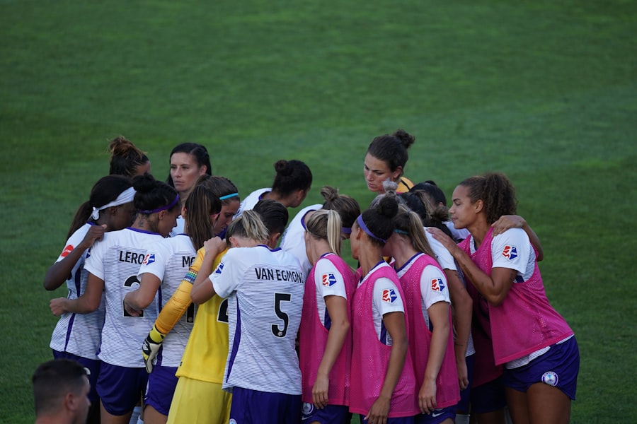 A sports team huddled together on the pitch