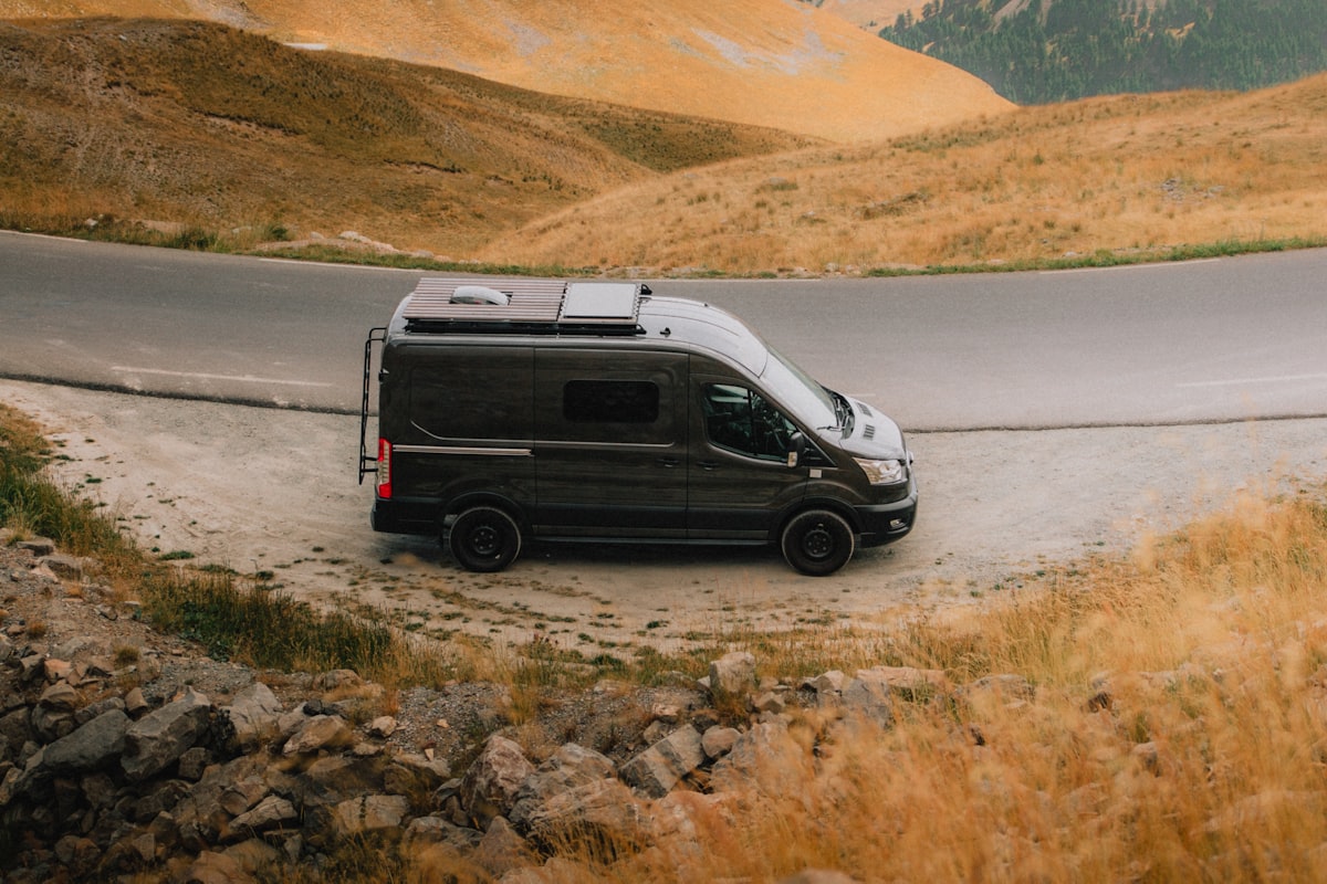 Ford Transit passenger van parked beside a winding highway